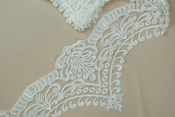 Obraz premium Texture lace fabric. lace on white background studio. thin fabric made of yarn or thread. a background image of ivory-colored lace cloth. White lace on beige background.