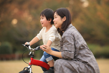 自転車に乗る練習をする親子