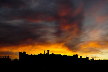 Obraz premium Moody Sunset Over the Rooftops.