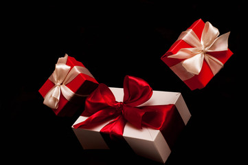 Gift box with white ribbon on black background. zero gravity. levitation. milimalism. Concept sales, shopping, christmas holidays, valentin's day and birthday.