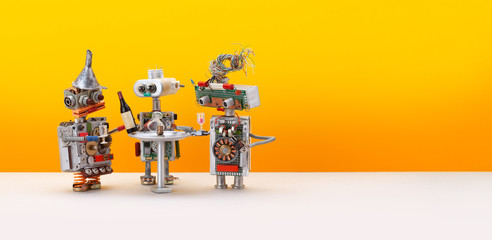 Robotic drink party. Three toy robots celebrate new system update. Yellow background, copy space
