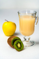 Juicy smoothie from apples and kiwi in a glass cup on a white background