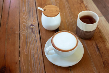 Cappuccino Cup Tea and sugar cups on a wooden table