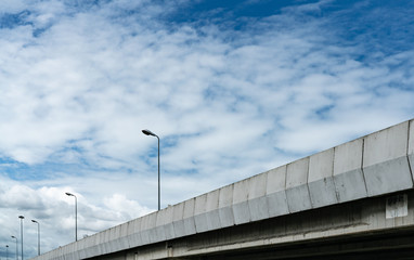 Elevated concrete highway and street lamp pole. Overpass concrete road. Road flyover. Modern motorway. Transportation infrastructure. Concrete bridge engineering construction. Bridge architecture.