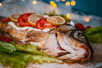 Baked stuffed fish carp with vegetables.