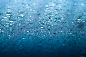 Wet windshield, blue glass surface