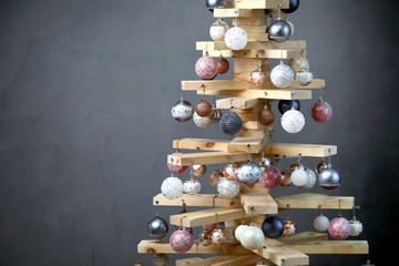 Alternative Christmas tree .  Christmas tree in the new year of wood boards, decorated with balls,...