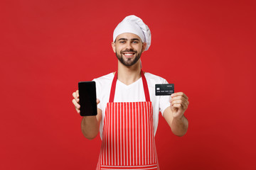 Smiling chef cook or baker man in striped apron t-shirt toque chefs hat isolated on red background....