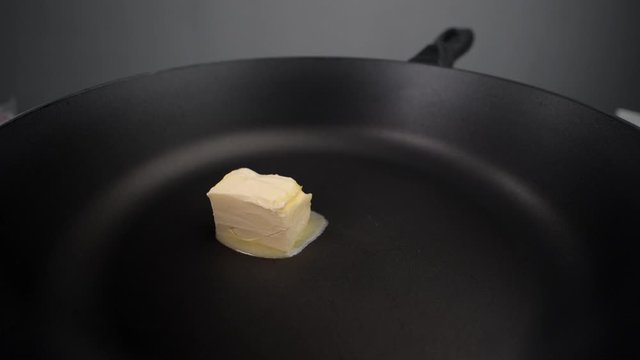 Butter melts on the hot pan in slow motion, greasing the pan, preaprations for roasting, cooking with milk products, Full HD 240 fps Prores 422 HQ