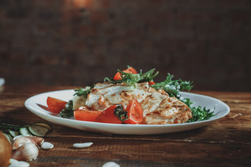 Grilled chicken breast. Grilled chicken fillet and salad of fresh vegetables from tomatoes, cucumbers and arugula leaves. Chicken meat salad. Healthy food. The apartment was lying. View from above.