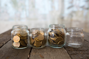 Fototapeta na wymiar Glass jars with money coins ruble on wooden table