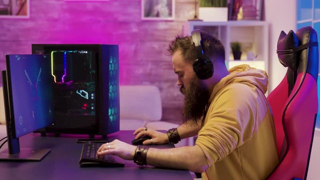 Professional game player wearing headphones in a room with colorful neons