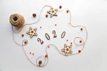 Flat lay of christmas wooden decorations and copybook with 2020 numbers on the white background. CHristmas flatlay concept. 