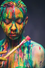 Möbelaufkleber Junge Frau bedeckt mit einer bunten Farbe © Nejron Photo