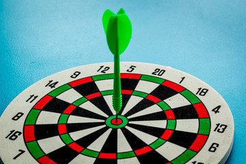 Darts game - simple sport for lesure time. Dartboard and arrows or dart on dark wooden background...