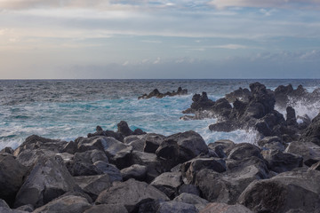 Fototapeta na wymiar Lava stones on the beach of Piscinas Naturais Biscoitos. Atlantic Ocean. Terceira Azores, Portugal.