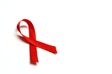 Red ribbon as symbol of aids awareness on white background with copy space for text.