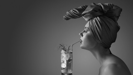 Beautiful woman with cocktail. Portrait of a young attractive woman in a fancy headdress.
