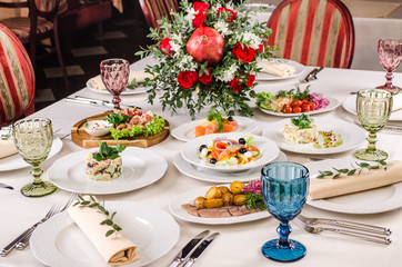 Beautiful restaurant interior table decoration for wedding or event. Flower Wedding Table Decoration, Autumn colors. European food in a restaurant setting. Table set for party.