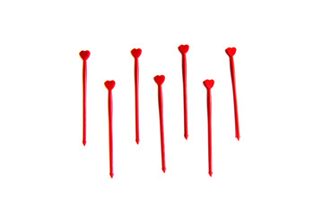 Red plastic sticks for canapes with a heart on a white isolated background. Decorative chopsticks.