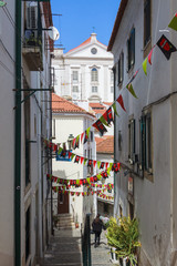 Lisbon, Portugal - May, 22nd, 2018 : Typical whitewashed narrow street in the Alfama, the oldest district of Lisbon.