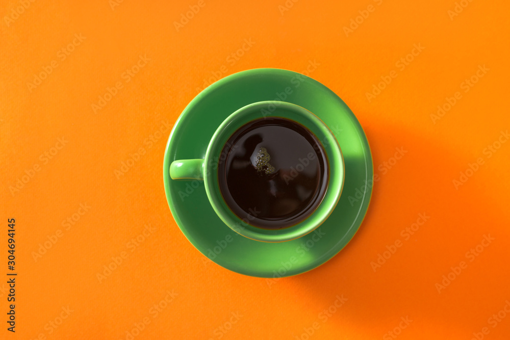 Wall mural green cup of coffee on orange background