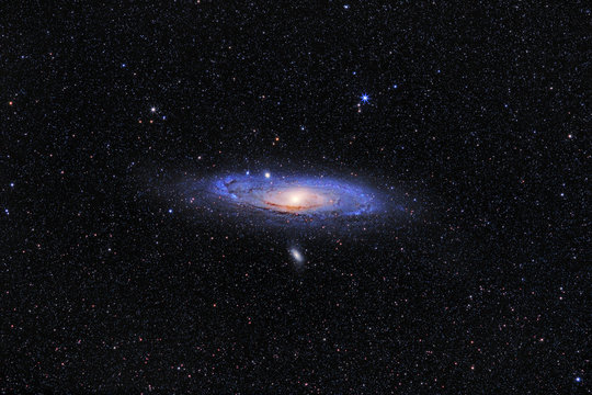 Andromeda Galaxy (M31) and its satellite galaxies (M32 and M110) in Andromeda constellation against widefield starry sky