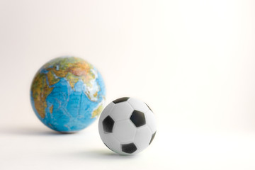 Fototapeta premium Globe and soccer ball on white background. December 10, World Football Day