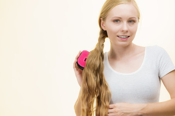 Blonde girl brushing her long hair
