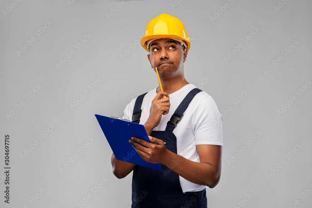 Poster profession, construction and building - thinking indian worker or builder in helmet with clipboard and pencil over grey background