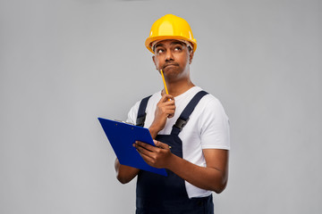 profession, construction and building - thinking indian worker or builder in helmet with clipboard...