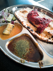 Indian Cuisine Tandoori Roti And Chicken Served in Metal Plate Also Called Chapati, Flatbread, Naan or Nan Bread on Dark Background