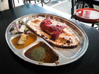 Indian Cuisine Tandoori Roti And Chicken Served in Metal Plate Also Called Chapati, Flatbread, Naan or Nan Bread on Dark Background