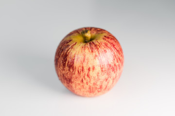 Fresh red yellow striped apples with water droplets on a white glossy kitchen table. Tasty bright juicy fruits. Healthy eating Isolated object	