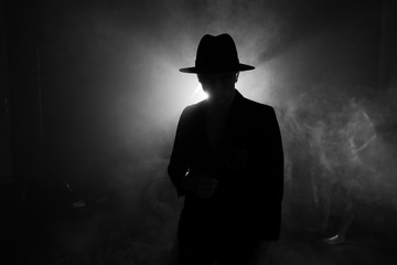 Silhouette of a man in a hat against the light, backlit guitar concert, performance with contrast