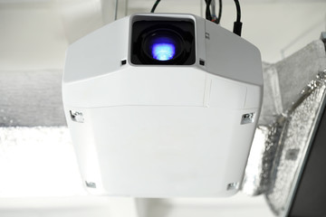 Modern video projector hanging on ceiling, closeup