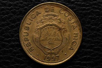 Costa Rican colones coin on black leather