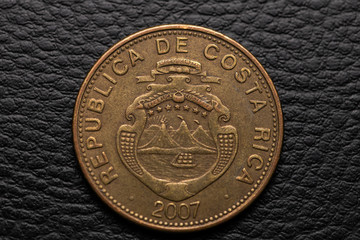 Costa Rican colones coin on black leather