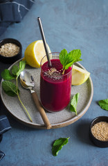 Smoothie de remolacha. Pajita de metal. Hojas de hierbabuena, sésamo y limón. 