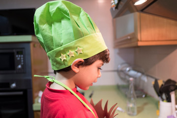 4 year old boy cooks macaroni at home with chef costume