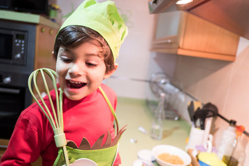 4 year old boy cooks macaroni at home with chef costume