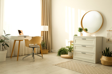 Stylish room interior with chest of drawers and round mirror