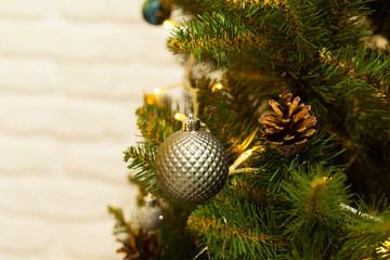 Beautiful green Christmas tree decorated with balls and garlands. Close-up photo