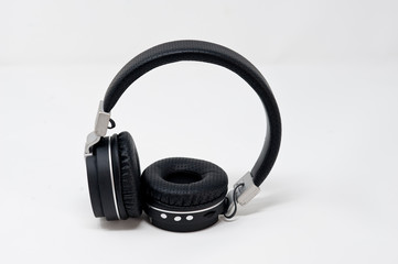 black and gray headphones placed in standing on white background