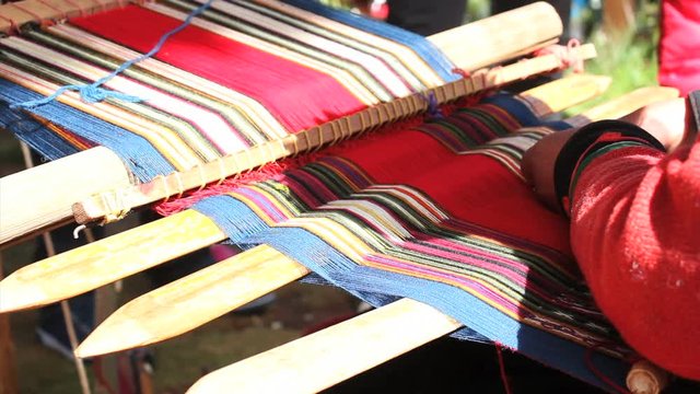 Woman shows process of production of the clothes from alpaca and llama