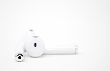 Small white headphones placed on white background 