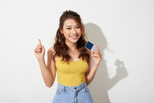 Photo of young smiling asian woman holding card