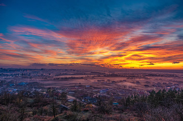 Sunset in the evening over the city in the fog