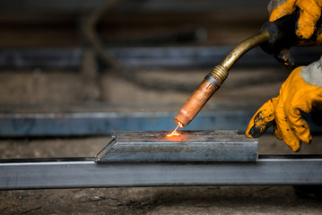 A man welder with construction gloves welding enthusiastically working and is welded with a welding...