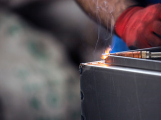 A man welder with construction gloves welding enthusiastically working and is welded with a welding...